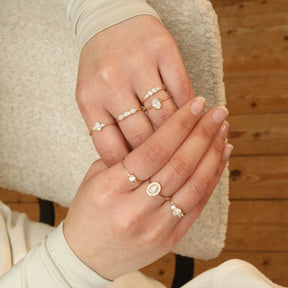 Close-up van handen met meerdere diamanten ringen van 9 en 14 karaat goud in een stijlvolle stacking look